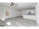 This bright living room features wood-look floors and a view into the kitchen with granite countertops and white cabinets at 458 Prescott Way, Villa Rica, GA 30180
