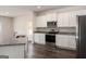 Modern kitchen with white cabinetry, granite countertops, and stainless steel appliances at 601 Mackenzie Cove, Villa Rica, GA 30180