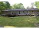 Backyard view featuring a spacious deck, a swing set, lush greenery, and room for outdoor activities at 142 Carrollwood Dr, Fayetteville, GA 30215