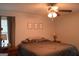 Bedroom featuring neutral decor, a ceiling fan, and bedside tables with lamps for a relaxing ambiance at 142 Carrollwood Dr, Fayetteville, GA 30215
