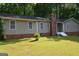 Ranch-style home featuring a brick chimney and base, with a tidy front lawn and landscaped features at 142 Carrollwood Dr, Fayetteville, GA 30215