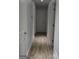 A well-lit hallway with light gray walls and wood-look flooring connecting different areas of the home at 142 Carrollwood Dr, Fayetteville, GA 30215