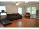 Spacious living room featuring hardwood floors, a comfortable sofa, and a treadmill for home workouts at 142 Carrollwood Dr, Fayetteville, GA 30215