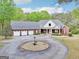 Expansive brick home with a circular driveway surrounded by lush greenery from above at 270 Morrow Rd, Newborn, GA 30056