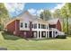 Back exterior of the house with brick and siding, a deck area, and a spacious yard with mature trees at 270 Morrow Rd, Newborn, GA 30056