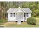 Inviting cottage with a white exterior, black shutters and a covered porch entryway at 270 Morrow Rd, Newborn, GA 30056
