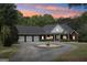 Stunning brick home with a circular driveway illuminated at dusk, showcasing its grand entrance and ample parking at 270 Morrow Rd, Newborn, GA 30056
