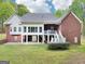 Back view of the brick home with a screened porch, white pillars, and covered patio at 270 Morrow Rd, Newborn, GA 30056