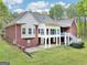 Rear view of the brick house showcasing a screened porch, patio, and spacious backyard at 270 Morrow Rd, Newborn, GA 30056
