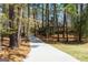Long concrete driveway surrounded by mature trees at 9995 Huntcliff Trce, Atlanta, GA 30350