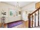 Light-filled foyer featuring patterned glass doors, hardwood floors, staircase, chandelier, and elegant decor at 9995 Huntcliff Trce, Atlanta, GA 30350