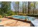 A covered in-ground pool with brick surround and colorful flowers around the perimeter at 9995 Huntcliff Trce, Atlanta, GA 30350