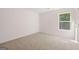 Bright bedroom with neutral carpet, white walls, and a window overlooking a wooded area at 1483 Autumn Wind Dr # 24, Dacula, GA 30019