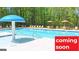Community pool with clear blue water, lounge chairs and sun umbrellas; Coming Soon sign at 1483 Autumn Wind Dr # 24, Dacula, GA 30019