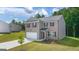 New construction two story home with brick and siding exterior, two car garage, and manicured lawn at 1483 Autumn Wind Dr # 24, Dacula, GA 30019