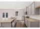 Bright kitchen features stainless steel appliances, gray cabinets and granite countertops at 1483 Autumn Wind Dr # 24, Dacula, GA 30019