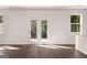 Bright living room featuring hardwood floors, glass doors to the yard, and natural light streaming in from the windows at 1483 Autumn Wind Dr # 24, Dacula, GA 30019