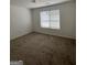 Cozy bedroom featuring a ceiling fan, neutral walls, and a large window at 2700 Marlin Dr, Mcdonough, GA 30253