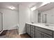 Modern bathroom with double vanity, wood-look floors, and a separate shower at 1511 Arica Ave, Lawrenceville, GA 30043