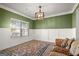 Cozy dining room with green accent wall, wainscoting, area rug and abundant natural light at 1511 Arica Ave, Lawrenceville, GA 30043