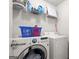 Well-organized laundry room with front loading washer and dryer, shelf, and supplies at 1511 Arica Ave, Lawrenceville, GA 30043