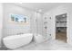 Bright bathroom with a soaking tub, glass shower, and a view from the window at 130 Windchime Way # 9, Tyrone, GA 30290