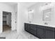 Bathroom with dual vanities, gray cabinets, and a view into the walk-in closet at 130 Windchime Way # 9, Tyrone, GA 30290