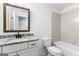 Bathroom features a wooden framed mirror, granite counters, and tiled bath at 130 Windchime Way # 9, Tyrone, GA 30290