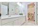 Bright bathroom features a dual sink vanity with white cabinets, a large mirror, and decorative shower curtain at 3435 Vista Creek Dr, Dacula, GA 30019