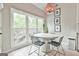 A sunlit dining area with modern lighting fixtures, table set and large window overlooking the exterior at 3435 Vista Creek Dr, Dacula, GA 30019