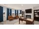 Home office featuring a fireplace, built-in bookshelves, hardwood desk, and neutral decor at 1809 Quaker, Hampton, GA 30228