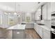 Bright kitchen features an island with white countertop, stainless appliances, and hardwood floors at 1809 Quaker, Hampton, GA 30228