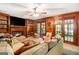 Living room with fireplace, wood paneling, built-in shelving, and french doors at 275 Brandon Mill Cir, Fayetteville, GA 30214