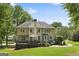 Expansive backyard with a lush lawn, a wooden deck, a stone patio, and mature trees surrounding the home at 240 Longmead Dr, Fayetteville, GA 30215