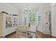 Bright dining room with hardwood floors, modern chandelier, a farmhouse table, and sun-filled windows at 240 Longmead Dr, Fayetteville, GA 30215
