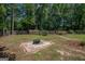 Large backyard with a fire pit area, surrounded by trees and a wooden fence at 101 Bluegill Trce, Peachtree City, GA 30269
