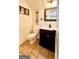 Neat half bathroom featuring tiled floors, dark wood vanity, mirror, and stylish fixtures at 101 Bluegill Trce, Peachtree City, GA 30269
