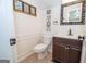 Cozy powder room with dark vanity, mirror, and framed art, adjacent to a tiled floor at 101 Bluegill Trce, Peachtree City, GA 30269