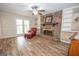 Inviting living room featuring wood floors, stone fireplace, built-in shelves, and a ceiling fan at 101 Bluegill Trce, Peachtree City, GA 30269