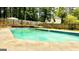 Backyard pool features a concrete deck and is surrounded by greenery and privacy fencing at 101 Bluegill Trce, Peachtree City, GA 30269