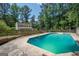Backyard pool surrounded by lush greenery and a wood fence next to a two-story home at 101 Bluegill Trce, Peachtree City, GA 30269