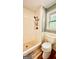Tiled shower with stone flooring, white tiling and modern fixtures next to a toilet and window at 101 Bluegill Trce, Peachtree City, GA 30269