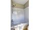 Bright bathroom showcasing a bathtub with a shower head and white tiled walls at 313 Country Club Dr, Jonesboro, GA 30238