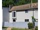Exterior view of a townhouse with a gray privacy fence and manicured bushes at 313 Country Club Dr, Jonesboro, GA 30238