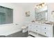 Bright bathroom featuring a white vanity, a large mirror, luxury fixtures, and a window at 1091 Pine St, Conyers, GA 30012
