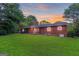 Charming brick home featuring a cozy front porch and a spacious, well-manicured lawn at 1091 Pine St, Conyers, GA 30012