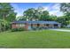 Charming single-story home featuring a brick and gray facade, complemented by a lush green lawn and mature trees at 1091 Pine St, Conyers, GA 30012