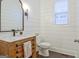 Stylish powder room featuring shiplap walls, decorative mirror, and rustic vanity at 405 Bandon Way, Peachtree City, GA 30269