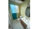 Outdated bathroom with a window, blue curtains, toilet, sink, and mirror at 5637 Sturbridge Way, South Fulton, GA 30349