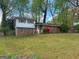 Charming split-level home with brick facade and red shutters is surrounded by a well-manicured lawn at 5637 Sturbridge Way, South Fulton, GA 30349